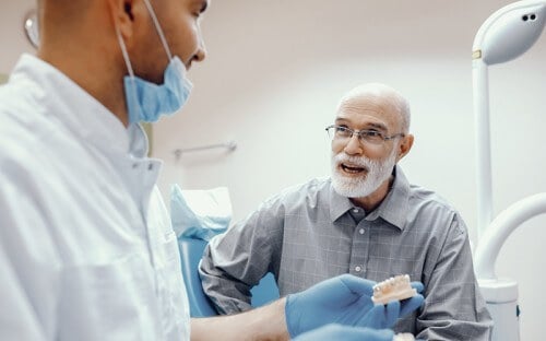 Elderly patient speaking with dentist in the practice